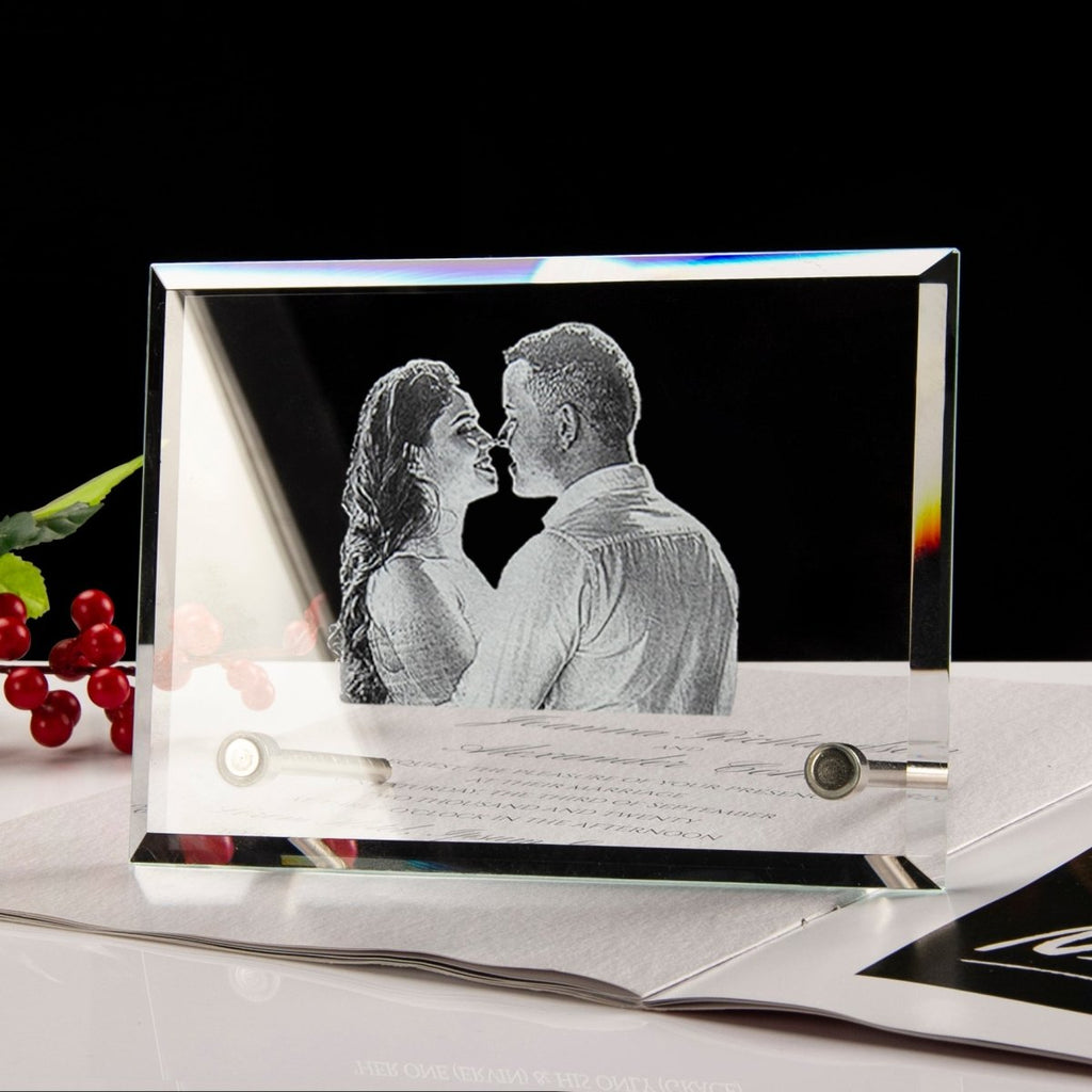 Glass photo frame with engraved couple and letter, surrounded by cherries on a dark background
