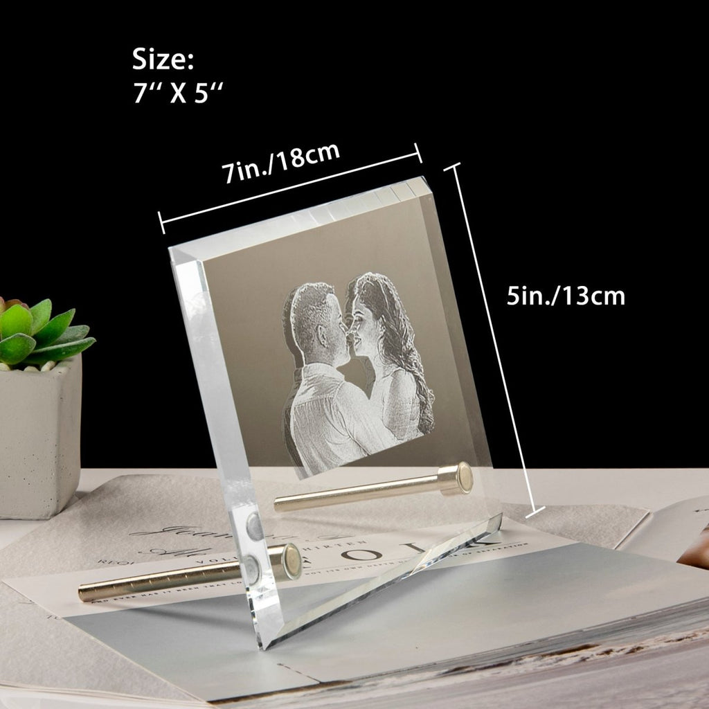 Silver photo frame with a couple's photo, placed on a surface with a black background.