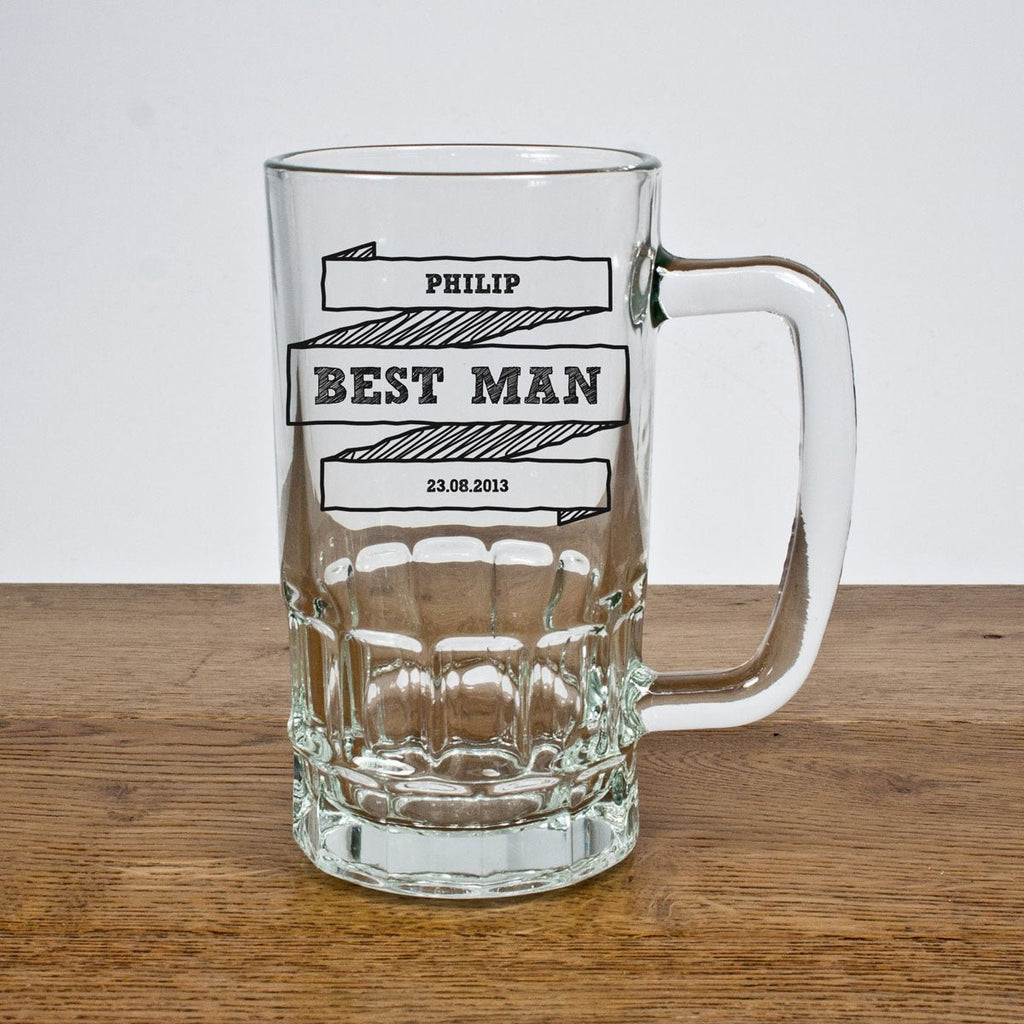 Clear glass mug with engraved text on a wooden surface