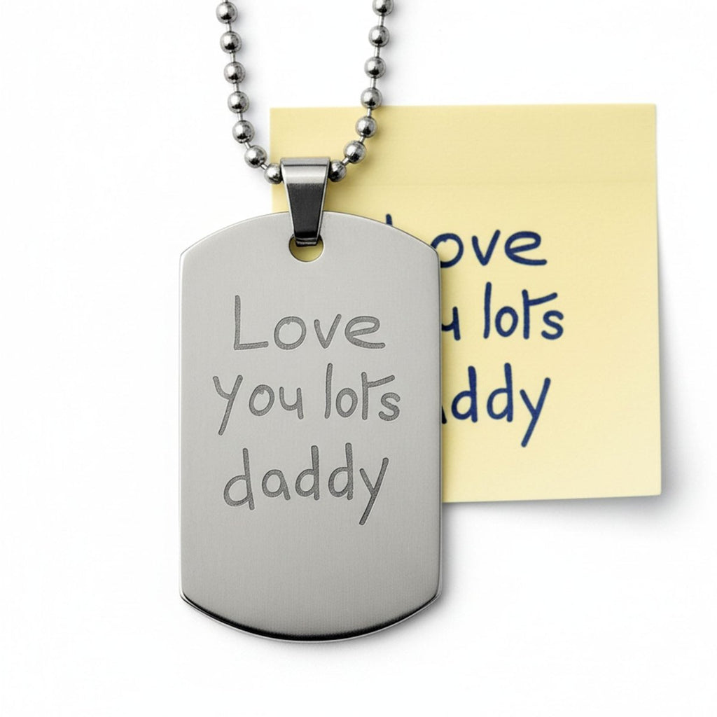 A silver dog tag necklace with the engraved message "Love You Lots Daddy" on it, hanging from a chain.