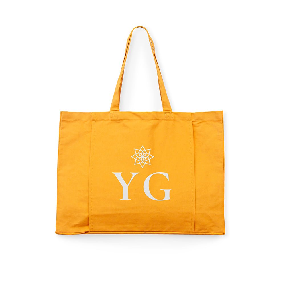 Yellow tote bag with 'YG' logo on a white background