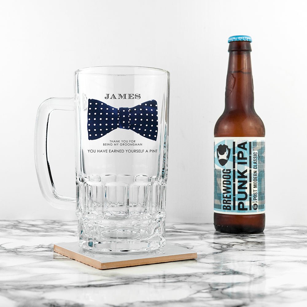 Personalized glass mug with bow tie design and a bottle of BrewDog Punk IPA on a marble surface.