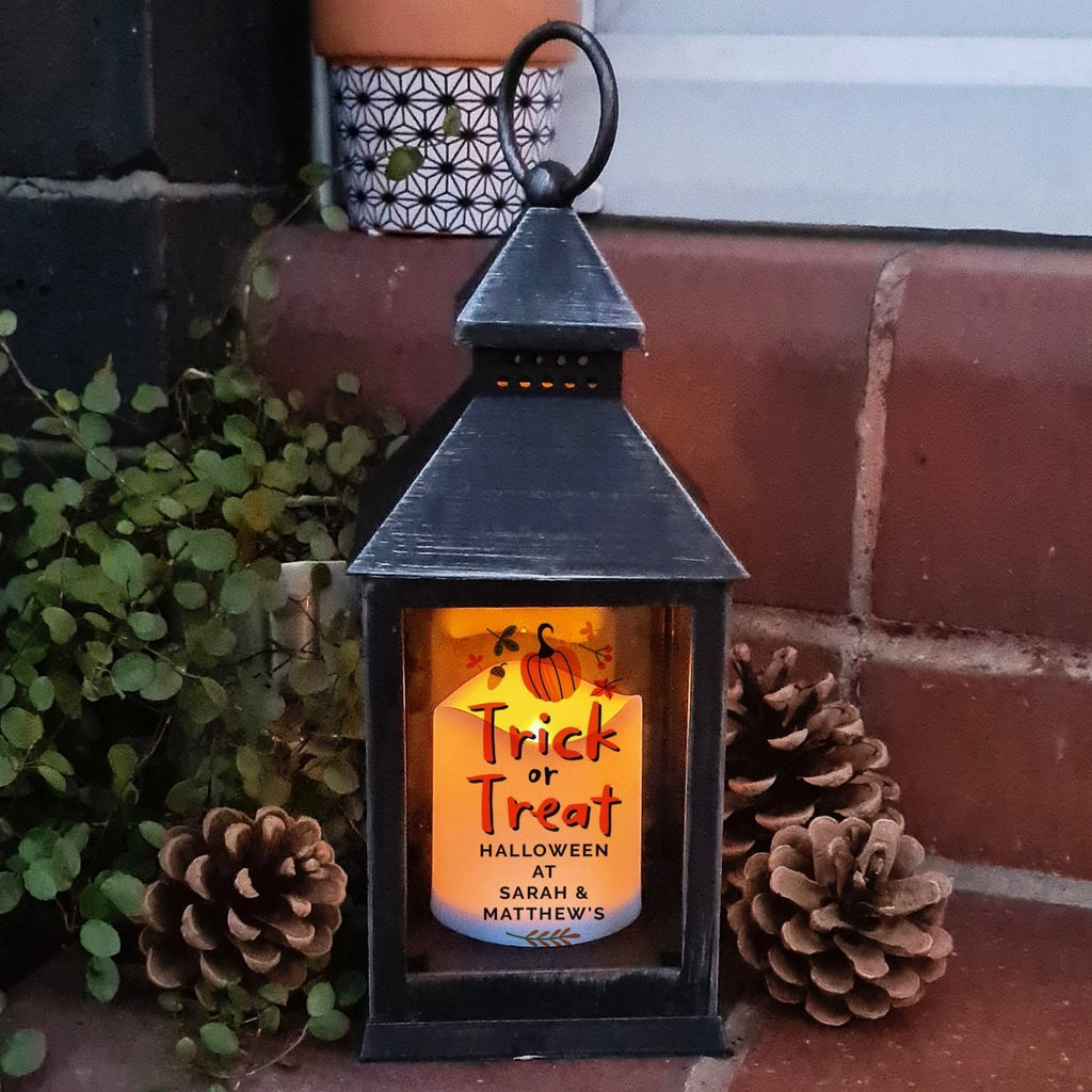 Light up Halloween with this personalized Trick or Treat lantern, featuring a flickering flame effect. Batteries not included.